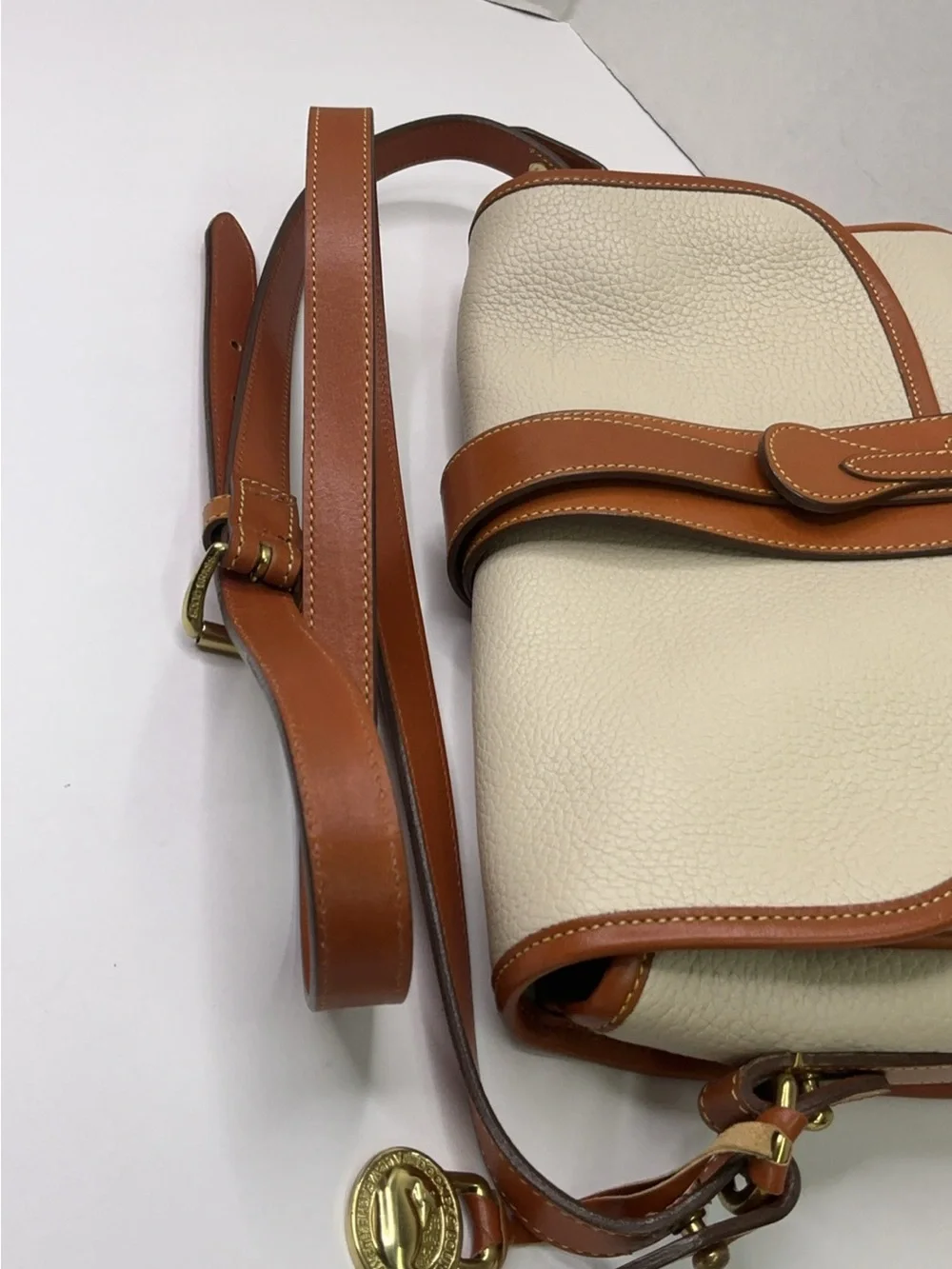 Dooney & Bourke cream and tan pebbled leather saddle bag